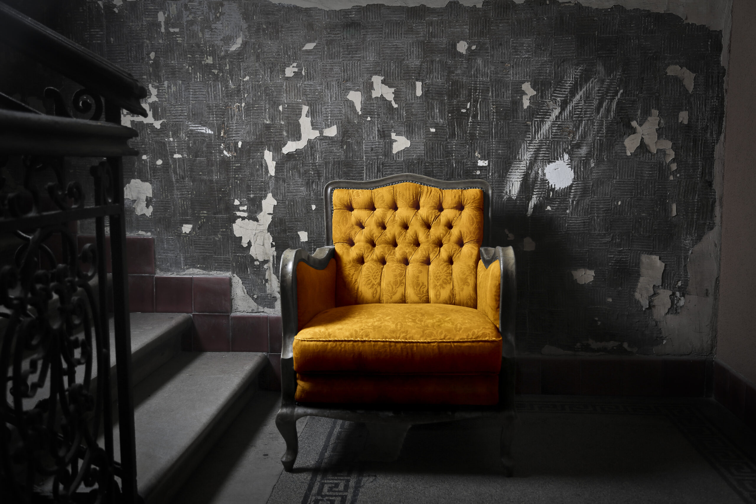 Alter gelber Sessel in altem Treppenhaus